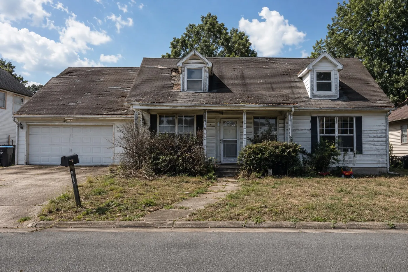 Storm-damaged roof with lifted and missing shingles before replacement