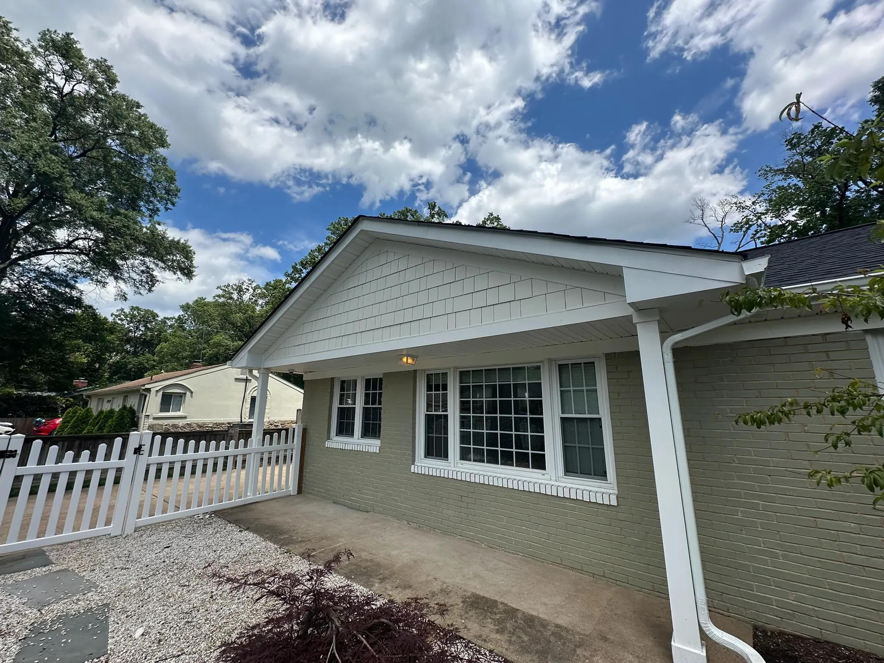 Freshly completed roof and exterior on a Northern Virginia home with a white picket fence