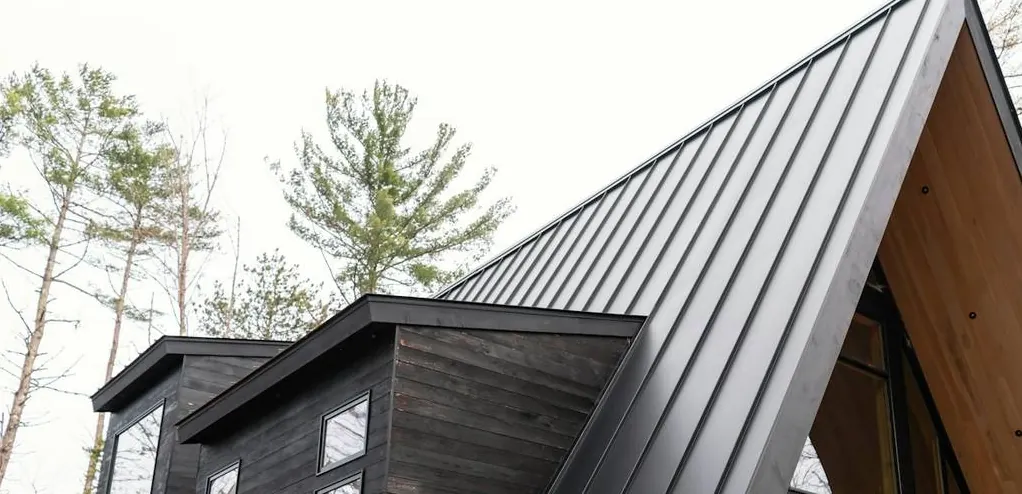 Standing-seam metal roof panels with crisp vertical seams on a steep pitch